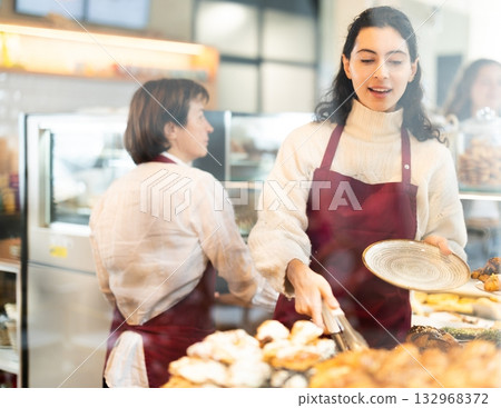 Woman folding fresh pastries 132968372