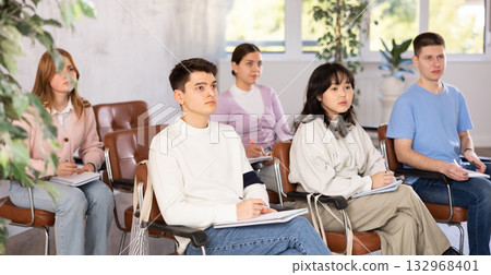 Group of high school students listening to lecture in auditorium 132968401