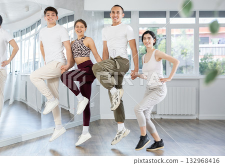 Group of girls and guys rehearsing Irish stepdance in dance studio Group of girls and guys rehearsing Irish stepdance in dance studio 132968416