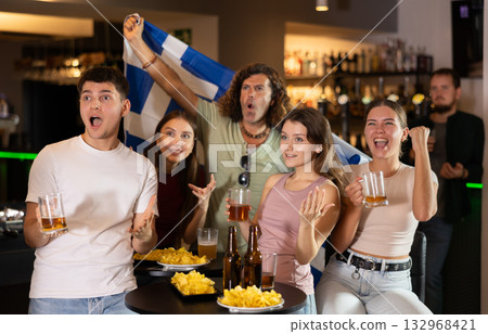 Group of friends cheer together for their favorite Greek team in beer bar Group of friends cheer together for their favorite Greek team in beer bar 132968421