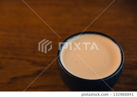 Creamy Coffee In Black Ceramic Mug On Wooden Table Close Up View Creamy Coffee In Black Ceramic Mug On Wooden Table Close Up View 132968841