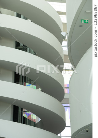 Modern Architectural Interior with Curved Staircases and Bright Skylight Modern Architectural Interior with Curved Staircases and Bright Skylight 132968867