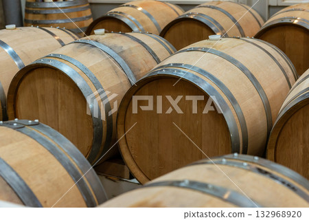 酒窖裡擺放著一排排的葡萄酒桶——酒莊儲藏室一覽。 酒窖裡擺放著一排排的葡萄酒桶——酒莊儲藏室一覽。 132968920