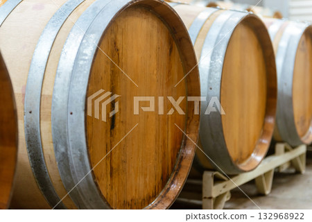 Aging cellar with rows of wine barrels - A view of the winery's storage room 132968922