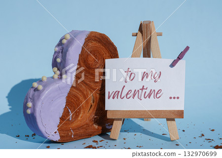 TO MY VALENTINE caption greeting card holiday present gift Valentine's Day Heart shaped blueberry flavor croissant on blue background with copy space. Puff pastry new trendy sweet dessert bakery TO MY VALENTINE caption greeting card holiday present gift Valentine's Day Heart shaped blueberry flavor croissant on blue background with copy space. Puff pastry new trendy sweet dessert bakery 132970699