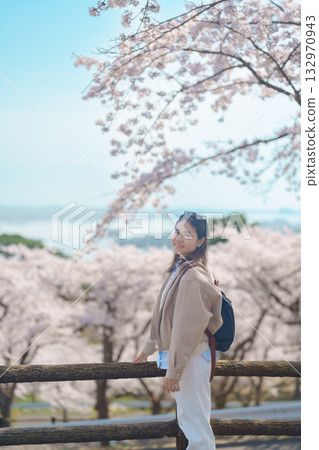 Woman tourist sightseeing Sakura Cherry Blossom in Spring. Happy traveler travel at Saigyo Modoshi no Matsu over Matsushima Bay in Matsushima, Miyagi Prefecture, Japan. Famous Landmark and Vacation 132970943