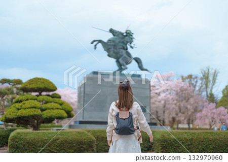 Woman tourist sightseeing Kajo Park Yamagata Castle Ruins with Sakura Cherry Blossom in Spring, happy traveler travel in Yamagata prefecture, Tohoku, Japan. famous Landmark for Travel and Vacation 132970960