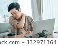 Overtired Asian man working with laptop in living room at home 132971364