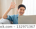 Young Asian man relaxing on comfortable couch, using laptop at home 132971367