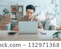 Happy young Asian man working on laptop in living room 132971368
