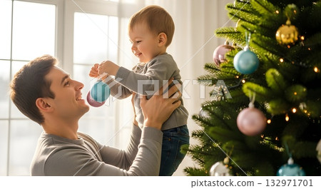 Father and son decorate Christmas tree with ornaments at home Father and son decorate Christmas tree with ornaments at home 132971701