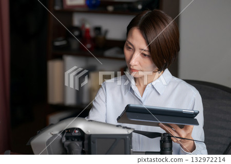 一名女子正在檢查無人機的運作情況。 132972214