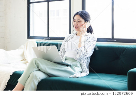 Woman using smartphone and computer at home Woman using smartphone and computer at home 132972609