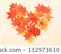 Heart-shaped arrangement of autumn leaves on a light wooden table 132973610