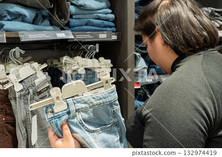Person shopping for jeans in clothing store 132974419