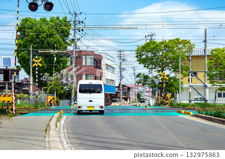 A car passing through a railroad crossing in a residential area A car passing through a railroad crossing in a residential area 132975863