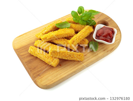 Crispy fried fish fingers with basil and ketchup on a wooden cutting board. 132976180