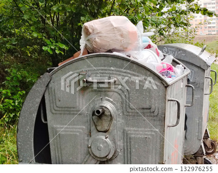 Overflowing metal dumpsters full of garbage bags. 132976255