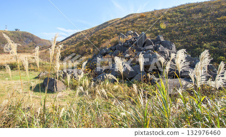 A walking path through the crater, featuring Japanese pampas grass and the hidden village of demons, with a view of the rotating observation deck in the distance, Oga Peninsula, Akita Prefecture 132976460