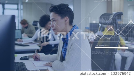 Reviewing notes woman in blue shirt working at desk in open-plan office, with data chart overlay Reviewing notes woman in blue shirt working at desk in open-plan office, with data chart overlay 132976942