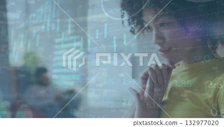 Analyzing woman wearing yellow shirt viewing digital financial charts in office lounge, copy space 132977020