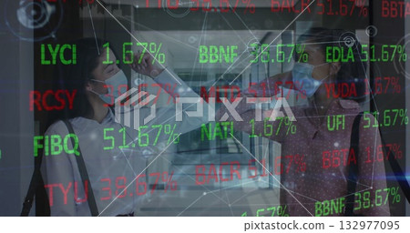 Coworkers wearing masks scanning foreheads with infrared thermometer in office, with stock overlay 132977095