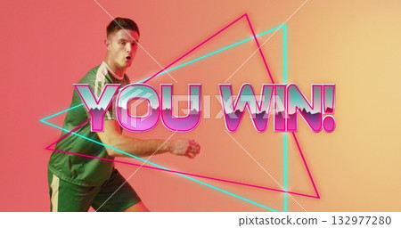 Reacting green-shirt athlete celebrating win in studio, with neon triangles, YOU WIN!, copy space 132977280