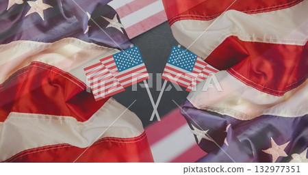 Displaying two crossed United States flags forming X in graphic art, with billowing flag fabric 132977351