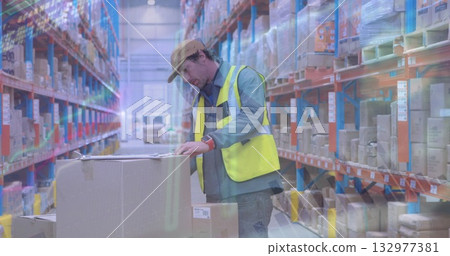 Worker wearing yellow safety vest checking boxes on pallet in warehouse aisle, with clipboard Worker wearing yellow safety vest checking boxes on pallet in warehouse aisle, with clipboard 132977381
