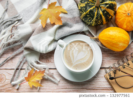 Autumn decoration with coffee cup, pumpkins, and a warm blanket Autumn decoration with coffee cup, pumpkins, and a warm blanket 132977561