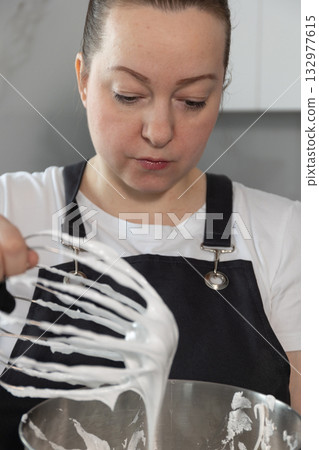 Whipped Cream Preparation by a Pastry Chef With Meringue in a Modern Kitchen Setting 132977615