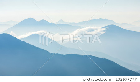 Misty mountain layers at sunrise for concept of nature, adventure, travel, or peaceful landscape 132977777