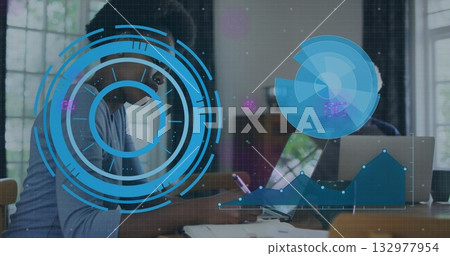 Woman and mature man collaborating in bright office, using tablet and laptop with charts overlay Woman and mature man collaborating in bright office, using tablet and laptop with charts overlay 132977954