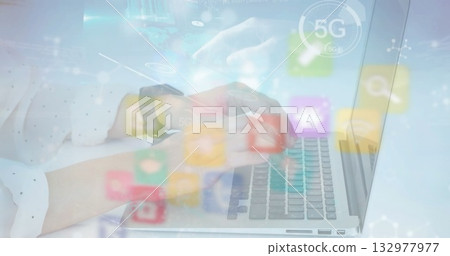 Typing woman wearing blouse and smartwatch on silver laptop at white desk, with 5G digital icons 132977977