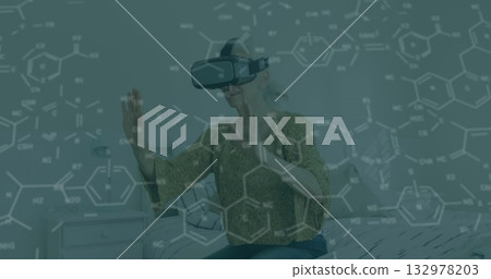 Manipulating molecules woman in patterned blouse using VR headset in bedroom, molecular overlay Manipulating molecules woman in patterned blouse using VR headset in bedroom, molecular overlay 132978203