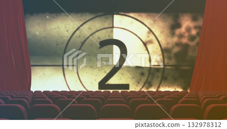 Showing large projection screen counting down number two in cinema auditorium, red velvet seats 132978312
