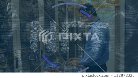 IT technician in blue shirt operating rack-mounted laptop in data center, with colorful cables 132978323