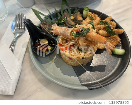 Stir Fried Chili Basil leaves with prawns on rice in a restaurant Stir Fried Chili Basil leaves with prawns on rice in a restaurant 132978895