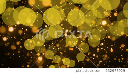 Glowing golden bokeh light circles forming abstract display in dark field, with glowing particles Glowing golden bokeh light circles forming abstract display in dark field, with glowing particles 132978929