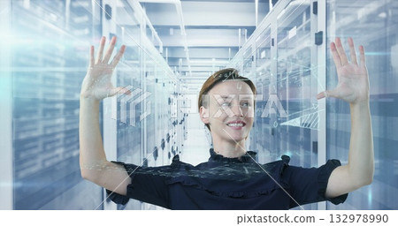 Engineer in ruffled top using holographic display in data center aisle, with server racks 132978990