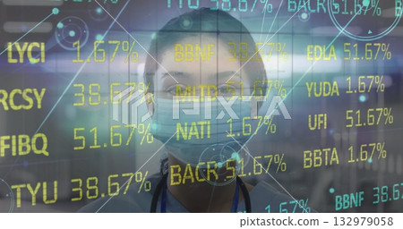 Nurse wearing scrubs, surgical mask and stethoscope analyzing data codes in hospital corridor 132979058