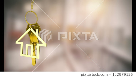 Hanging gold house-shaped keychain with metallic keys in hallway interior, with warm home concept Hanging gold house-shaped keychain with metallic keys in hallway interior, with warm home concept 132979136