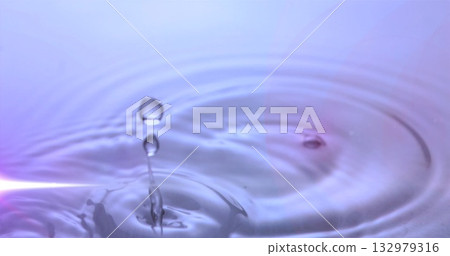 Suspending clear water droplet above studio pool, showing thin water column and circular ripples 132979316