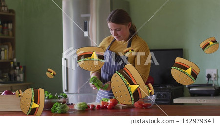 Adult woman chopping lettuce and cherry tomatoes in home kitchen, with floating hamburger cartoons Adult woman chopping lettuce and cherry tomatoes in home kitchen, with floating hamburger cartoons 132979341
