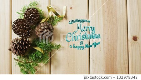 Pinecones with evergreen sprigs resting on wood panel, gold ribbon and teal greeting, copy space Pinecones with evergreen sprigs resting on wood panel, gold ribbon and teal greeting, copy space 132979342