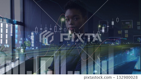 Woman in dark top reading financial charts on office window at night, with city lights Woman in dark top reading financial charts on office window at night, with city lights 132980028