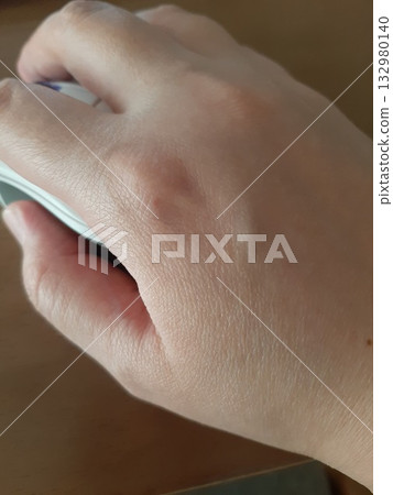 Woman's hand holding a mouse Woman's hand Woman's hand holding a mouse Woman's hand 132980140