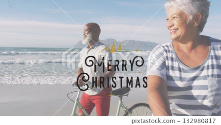 Standing man and pedaling woman wearing casual attire on sandy shore, with two bicycles and waves 132980817