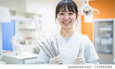 Smiling dental professional holds tools in bright clinic during daylight hours with modern equipment and warm atmosphere Smiling dental professional holds tools in bright clinic during daylight hours with modern equipment and warm atmosphere 132981064
