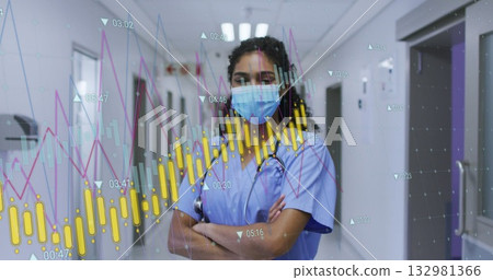 Standing nurse wearing blue scrubs viewing health charts in hospital corridor, with stethoscope 132981366